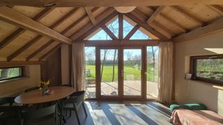 Woonkamer met grote glaswand en uitzicht op het bos